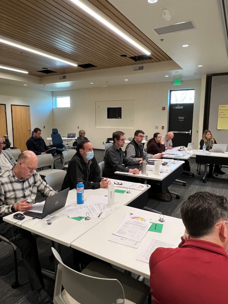 A variety of people sitting at connected tables during a meeting