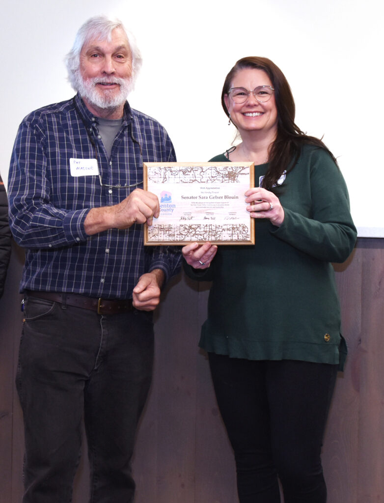 Commissioner Pat Malone presents a plaque to Senator Sara Gelser Blouin in appreciation of her funding support for the Oak Creek evacuation route.