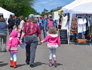 Visitors stroll between booths at the Monroe Festival