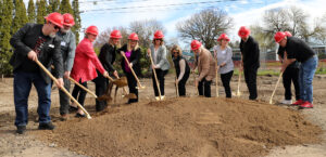 Corvallis Housing First representatives and state and local leaders lift the first shovel of dirt to break ground at the construction site