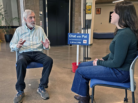 Commissioner Pat Malone chats with a community member in the lobby of the Kalapuya Building